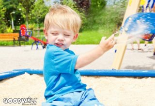 Foto van kindje dat gooit met zand-Goodwill.nl